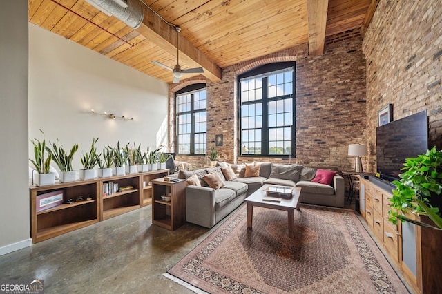 living room with wood ceiling, ceiling fan, a towering ceiling, brick wall, and beamed ceiling