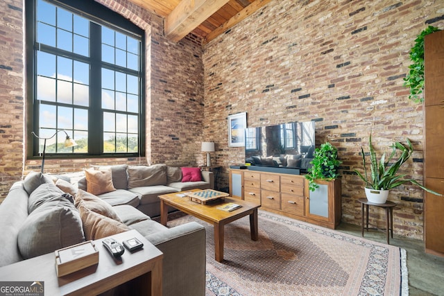 living room with beam ceiling, wood ceiling, a towering ceiling, and brick wall