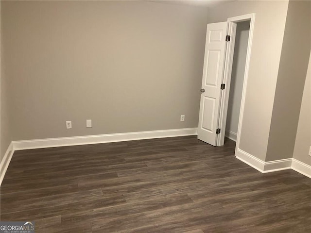 unfurnished room featuring dark wood-type flooring