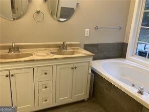 bathroom with vanity and a relaxing tiled tub