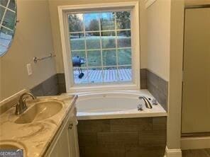 bathroom with vanity, a wealth of natural light, and independent shower and bath