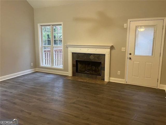 unfurnished living room with dark wood-type flooring and a fireplace