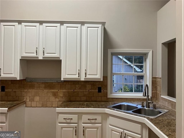 kitchen featuring backsplash, sink, and white cabinets