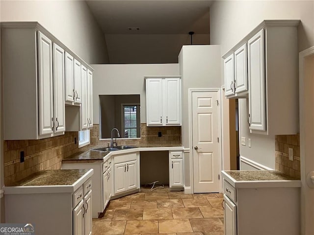 kitchen featuring sink, decorative backsplash, and white cabinets