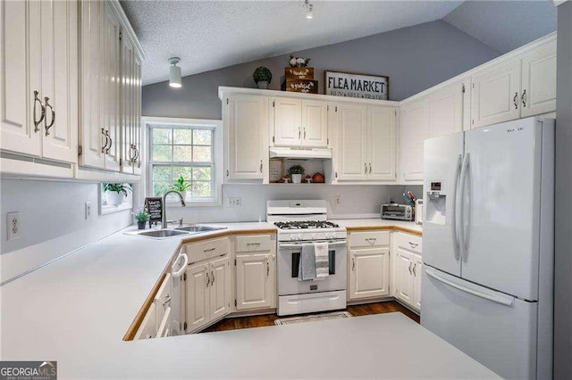 kitchen with white cabinetry, white appliances, lofted ceiling, and sink