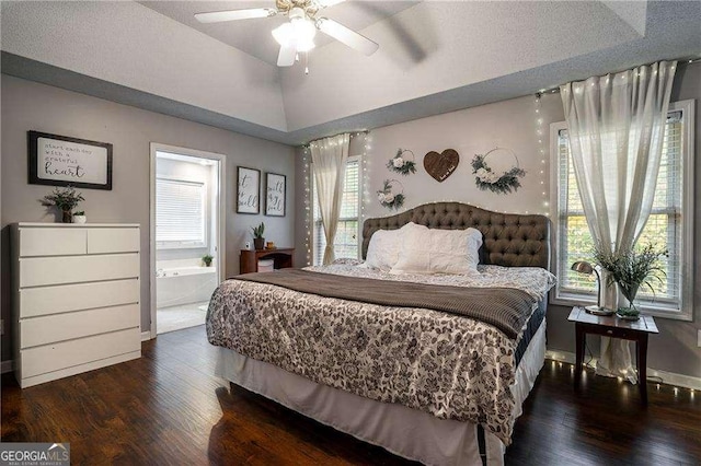 bedroom featuring vaulted ceiling, dark hardwood / wood-style floors, ceiling fan, and ensuite bathroom