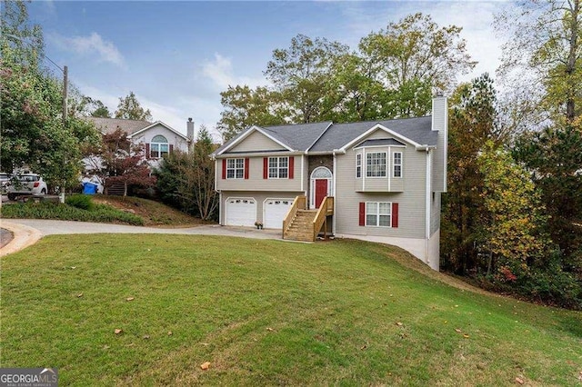 raised ranch featuring a garage and a front yard