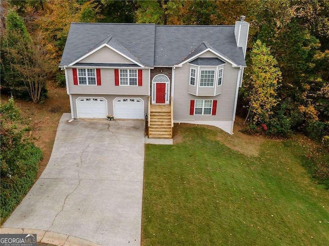 bi-level home with a garage and a front yard