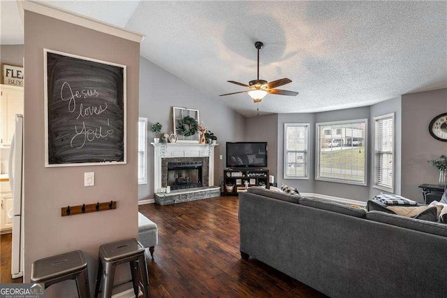 living room featuring dark wood-type flooring, a stone fireplace, vaulted ceiling, a textured ceiling, and ceiling fan