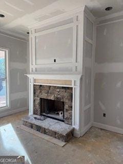 unfurnished living room featuring a fireplace and ornamental molding