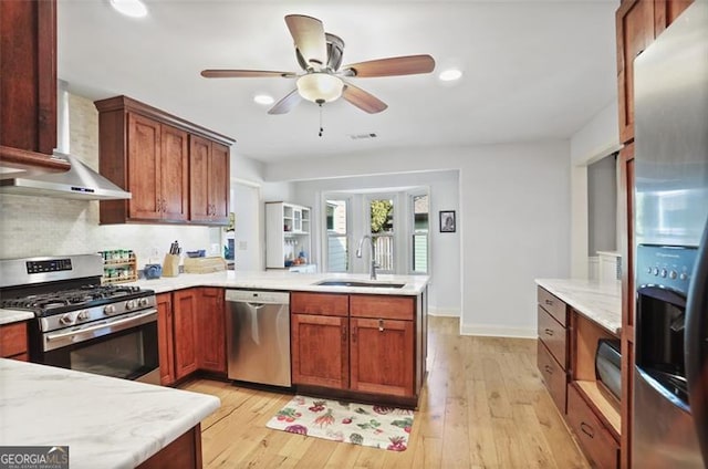 kitchen with sink, light hardwood / wood-style flooring, backsplash, stainless steel appliances, and kitchen peninsula