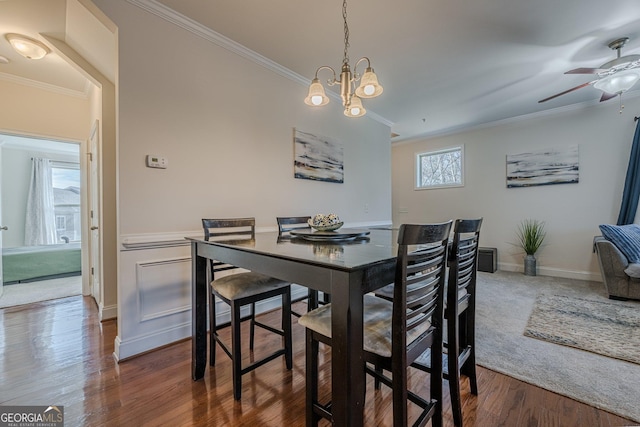 dining room with baseboards, an inviting chandelier, wood finished floors, and crown molding