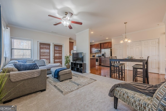 living room featuring ornamental molding, ceiling fan with notable chandelier, recessed lighting, and wood finished floors