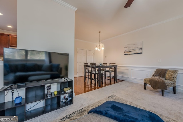 living area with carpet, wainscoting, crown molding, and a decorative wall