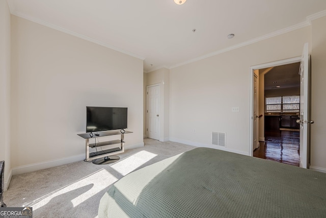 carpeted bedroom featuring ornamental molding, visible vents, and baseboards