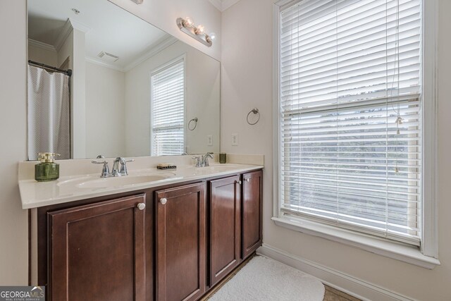 bathroom with ornamental molding, visible vents, a sink, and double vanity