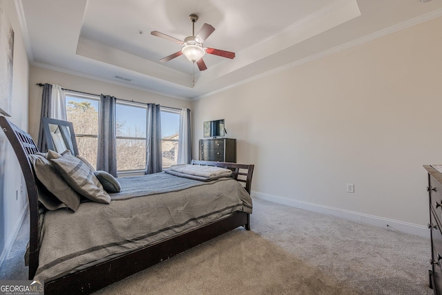 bedroom featuring carpet, a raised ceiling, crown molding, and baseboards