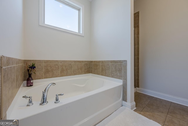 full bath featuring baseboards, a bath, and tile patterned floors