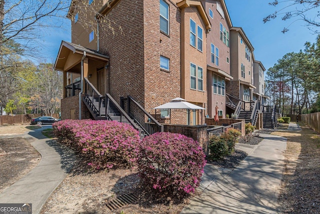 view of property featuring stairs, fence, and a residential view