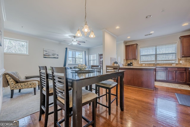 dining space featuring recessed lighting, wood finished floors, visible vents, and crown molding