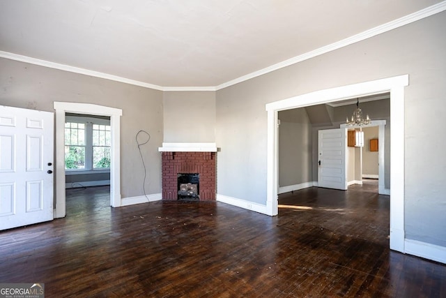 unfurnished living room featuring dark wood-type flooring, ornamental molding, a fireplace, and a notable chandelier