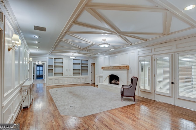 unfurnished living room with coffered ceiling, built in shelves, ornamental molding, and light hardwood / wood-style floors