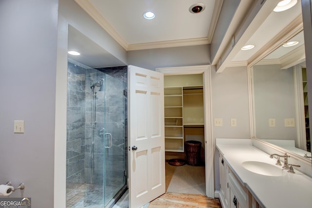 bathroom featuring crown molding, vanity, a shower with shower door, and wood-type flooring