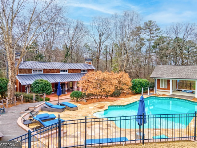 view of swimming pool with an outdoor structure and a patio area