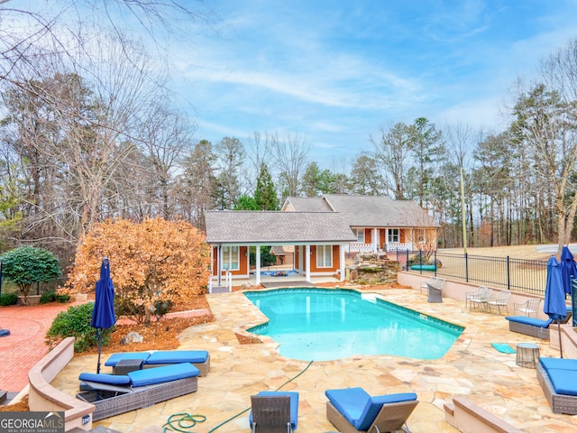 view of swimming pool featuring a patio and an outdoor structure