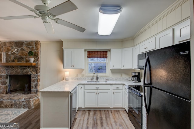 kitchen with black appliances, sink, white cabinets, kitchen peninsula, and light wood-type flooring