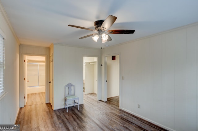 interior space with hardwood / wood-style flooring, ceiling fan, and ornamental molding