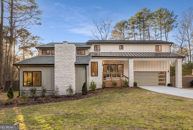 view of front of home featuring a garage, a front yard, and covered porch