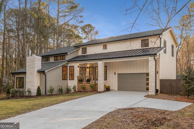 modern farmhouse featuring a garage, a front lawn, and a porch