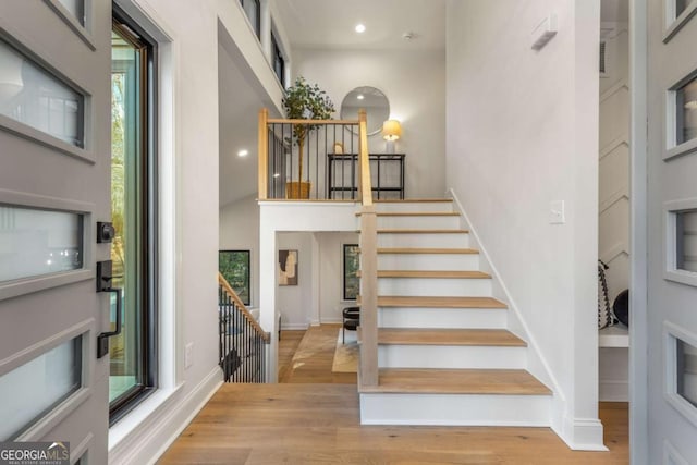 stairway with a high ceiling and hardwood / wood-style floors