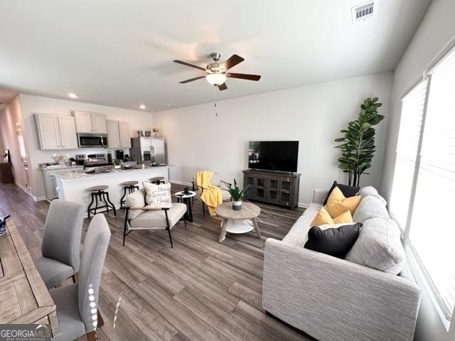 living room with hardwood / wood-style floors and ceiling fan