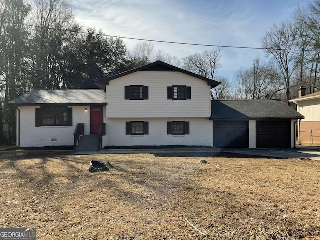 split level home with a garage and a front lawn