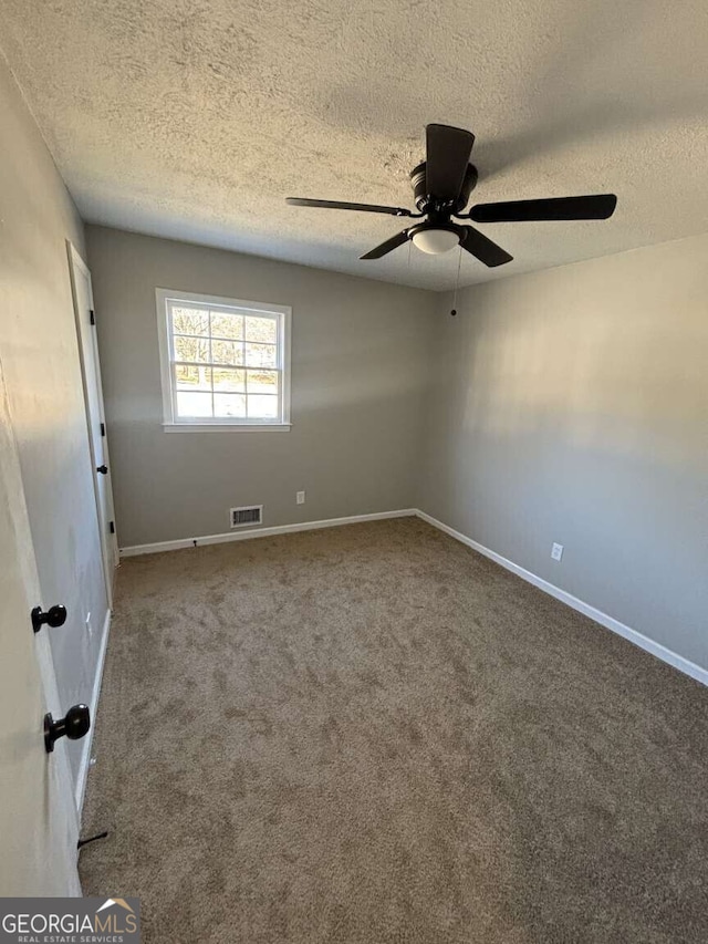 carpeted spare room featuring a ceiling fan, baseboards, visible vents, and a textured ceiling