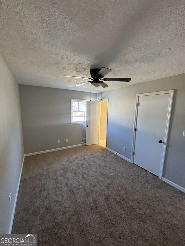 unfurnished bedroom with carpet floors, visible vents, ceiling fan, and baseboards