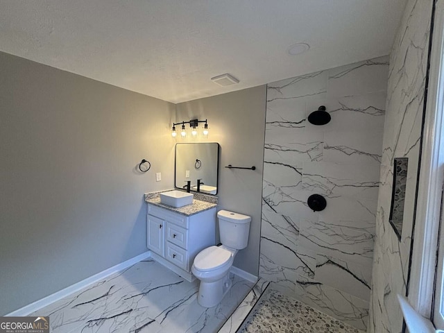 bathroom with a marble finish shower, baseboards, toilet, marble finish floor, and vanity