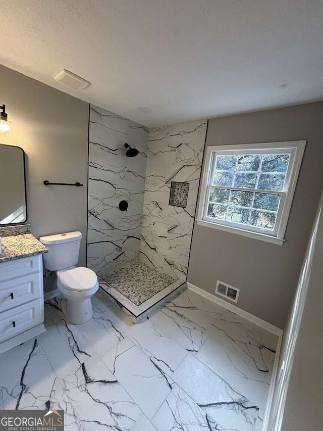 full bath featuring vanity, visible vents, baseboards, marble finish floor, and a marble finish shower