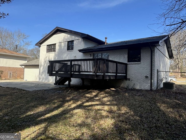 back of property with brick siding, fence, a yard, a wooden deck, and a patio area