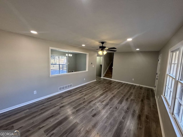 unfurnished room with dark wood-style floors, baseboards, stairs, and visible vents