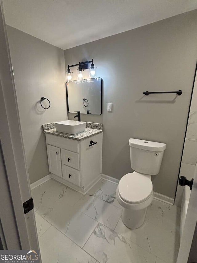 bathroom featuring marble finish floor and baseboards