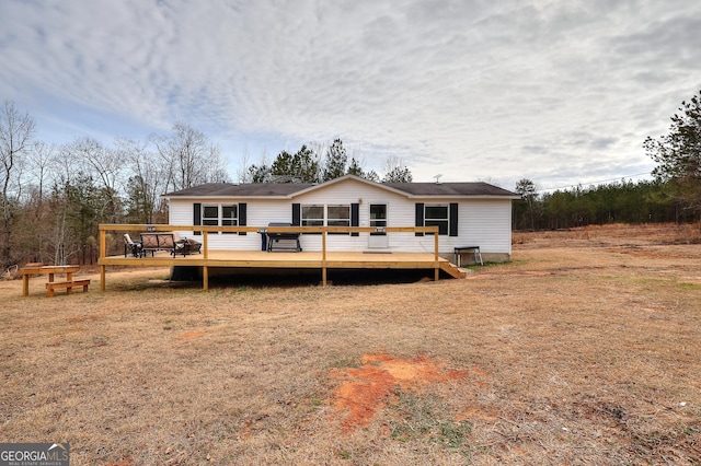 rear view of property featuring a wooden deck