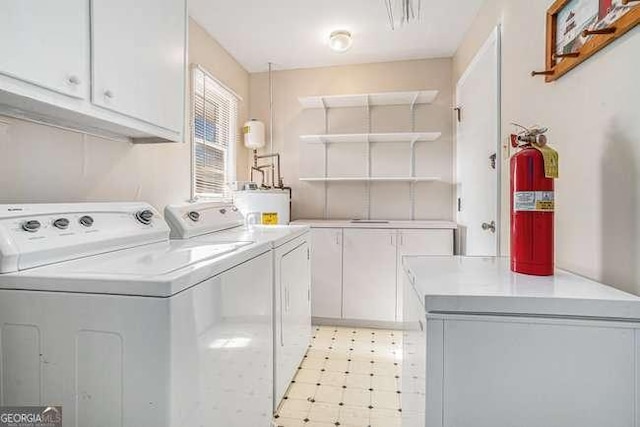 laundry room featuring cabinets, separate washer and dryer, and electric water heater