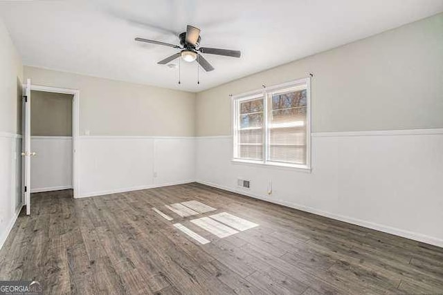 spare room with dark hardwood / wood-style flooring and ceiling fan