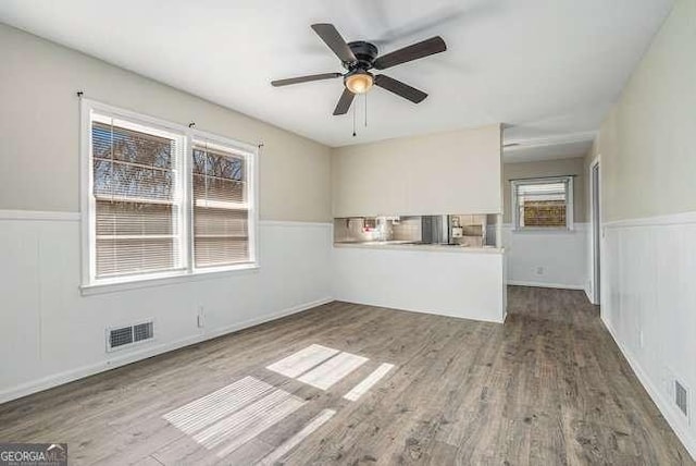 unfurnished living room featuring ceiling fan and hardwood / wood-style floors