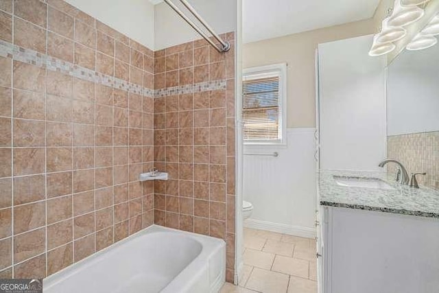 full bathroom featuring vanity, tile patterned flooring, tiled shower / bath combo, and toilet