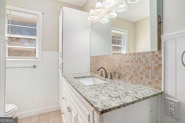 bathroom featuring tile patterned flooring, vanity, backsplash, and toilet