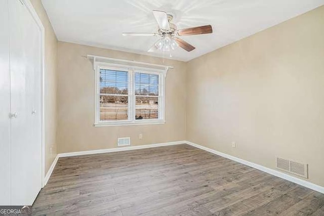 spare room with hardwood / wood-style floors and ceiling fan